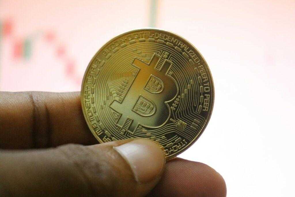 a person holding a bit coin in their hand