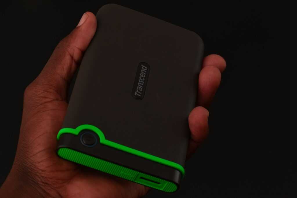 a hand holding a green and black cell phone