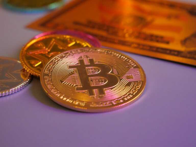 Golden bitcoin coin with other coins and card.