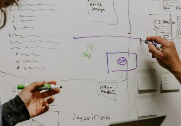 two people drawing on whiteboard