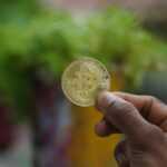 a person holding a bit coin in their hand