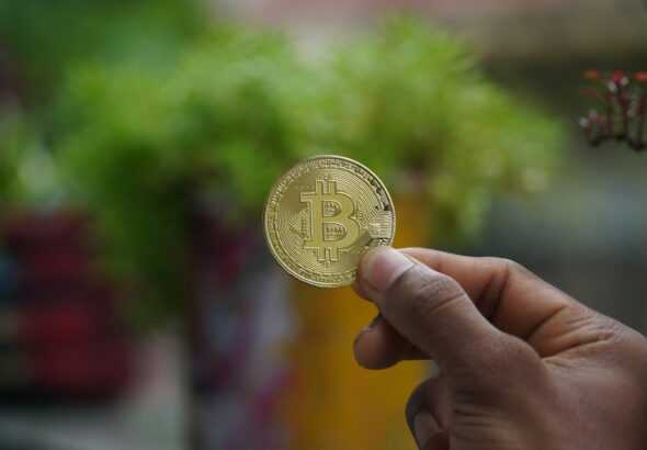 a person holding a bit coin in their hand